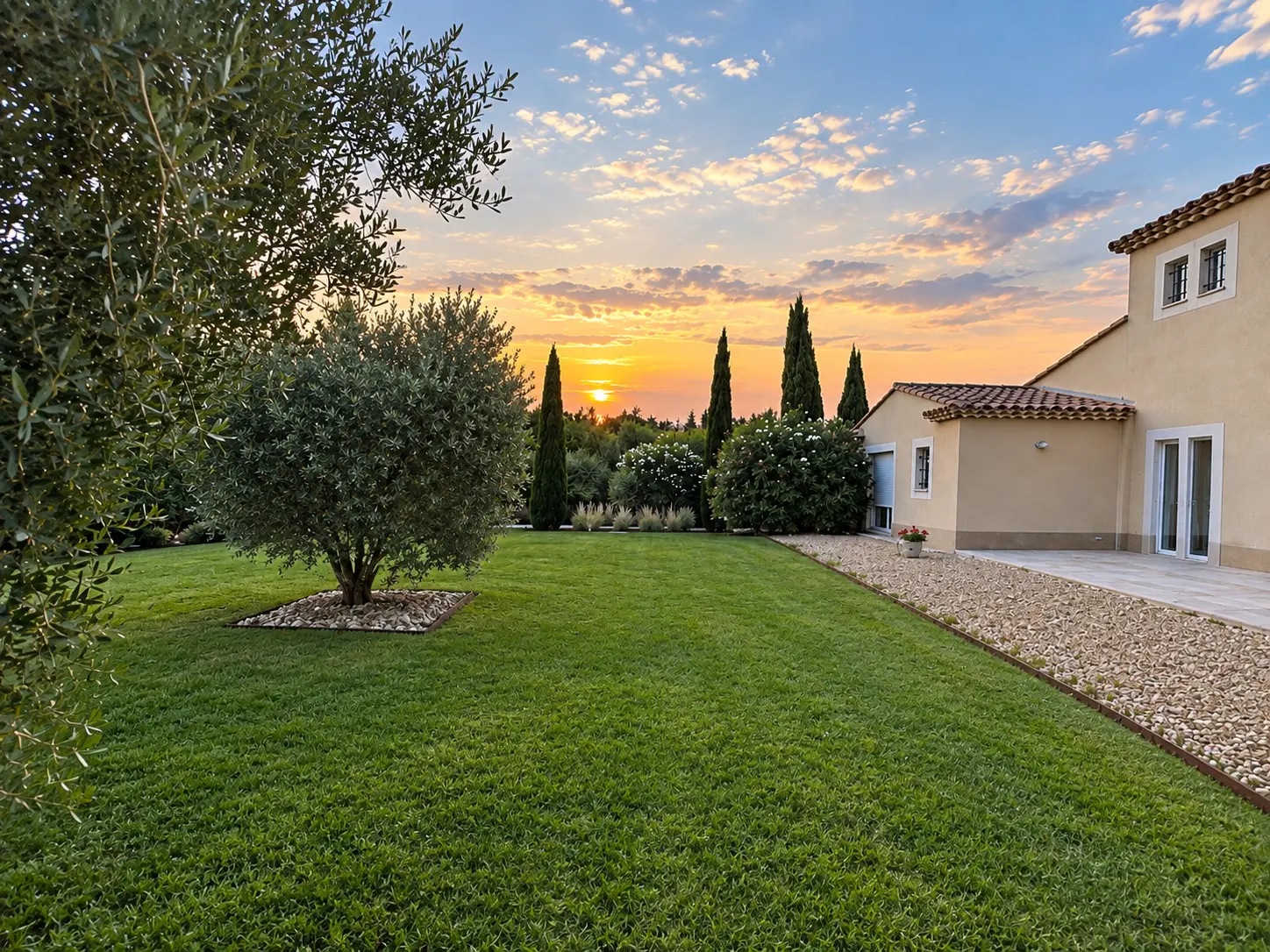 Le jardin au coucher du soleil, avec la maison et les cyprès