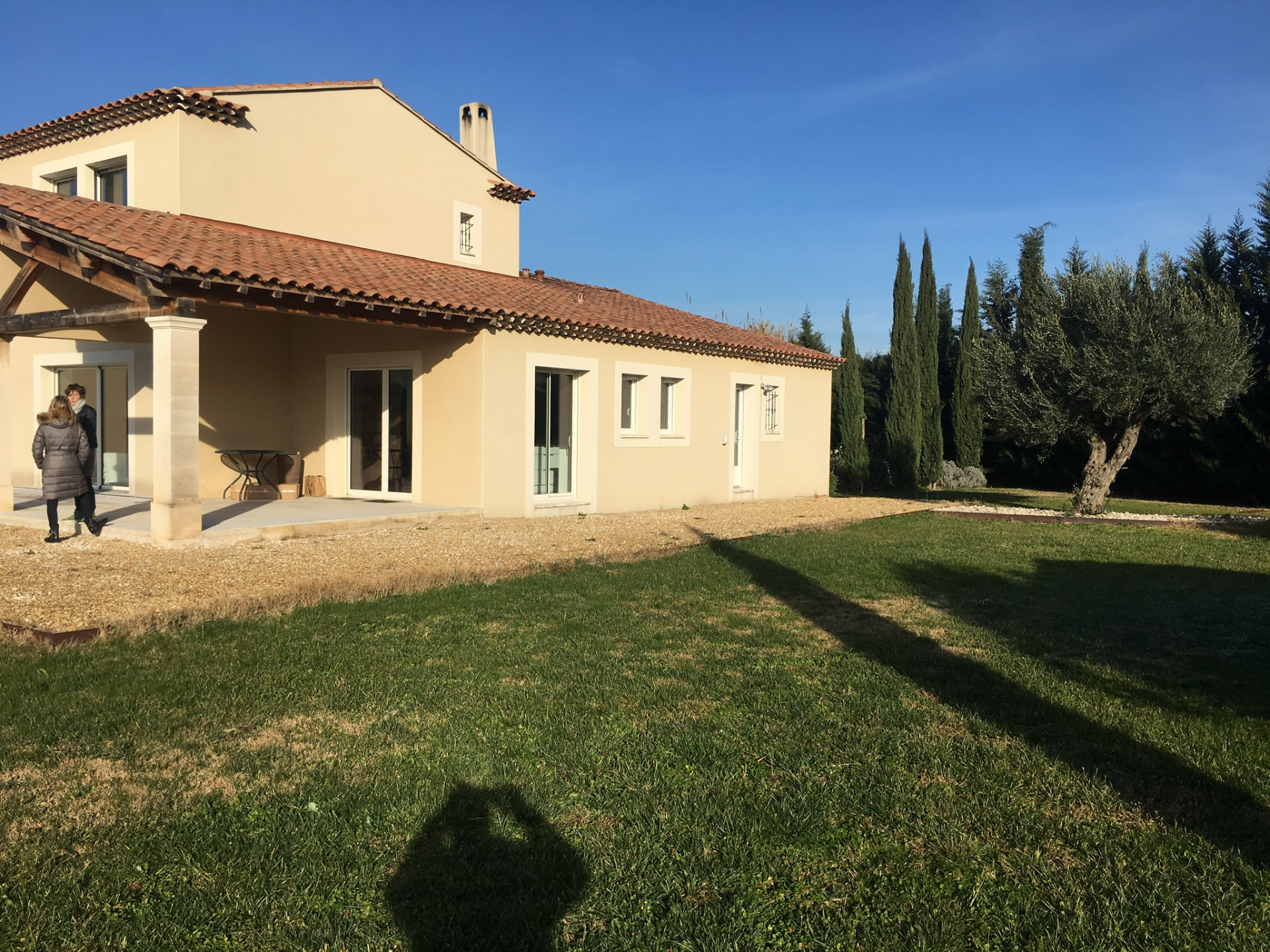 La façade est de la maison, bordée de cyprès et d'un olivier